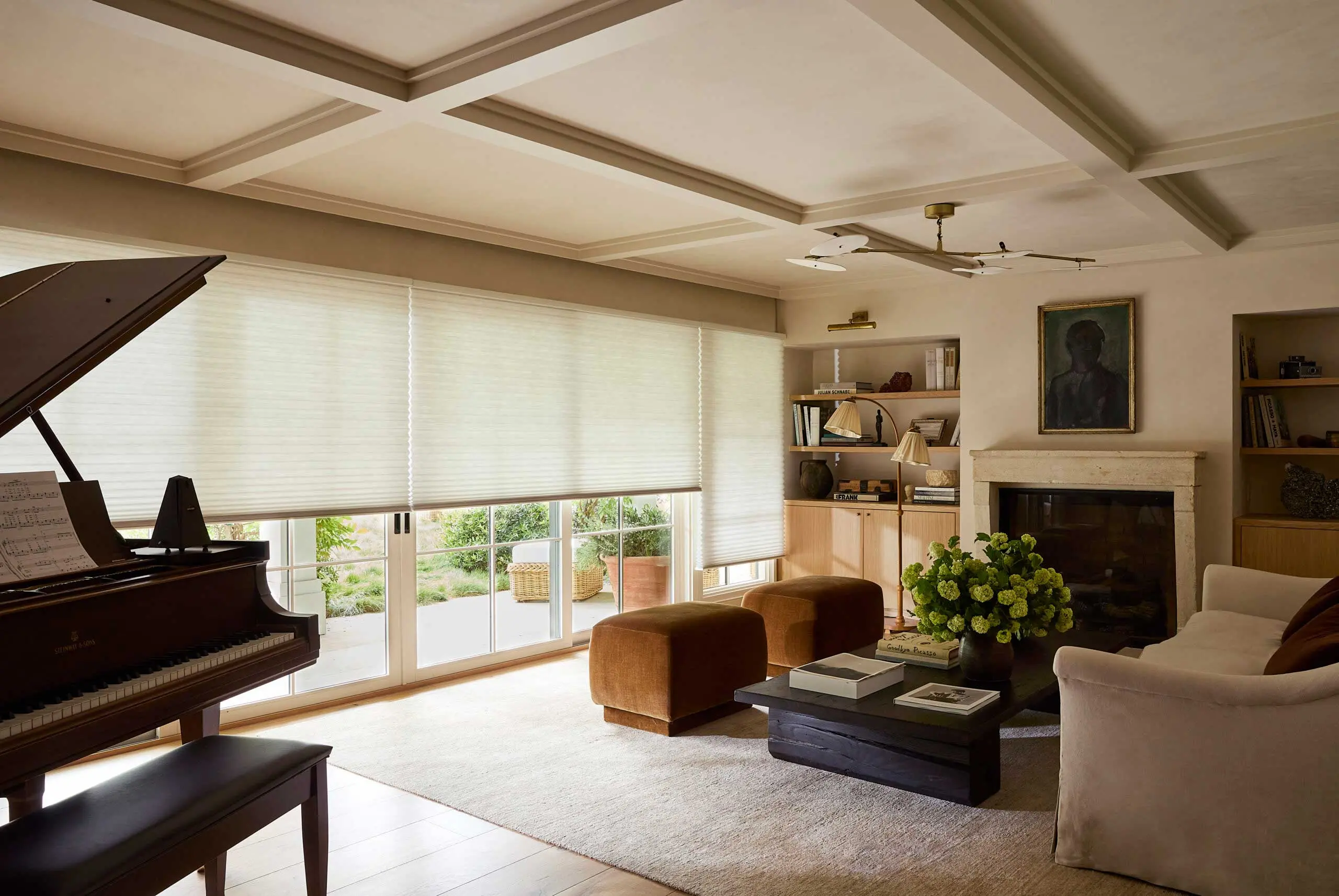 A living room with large windows featuring Hunter Douglas shades.